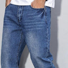 Worn blue denim wide-leg jeans with washed look, model wearing white shirt | Chaps London