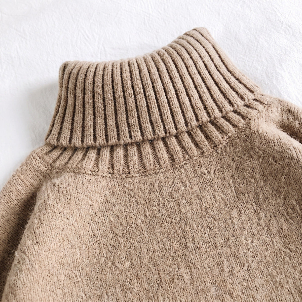 Tan ribbed turtleneck sweater knit fabric close-up, flat lay detail shot | Chaps London