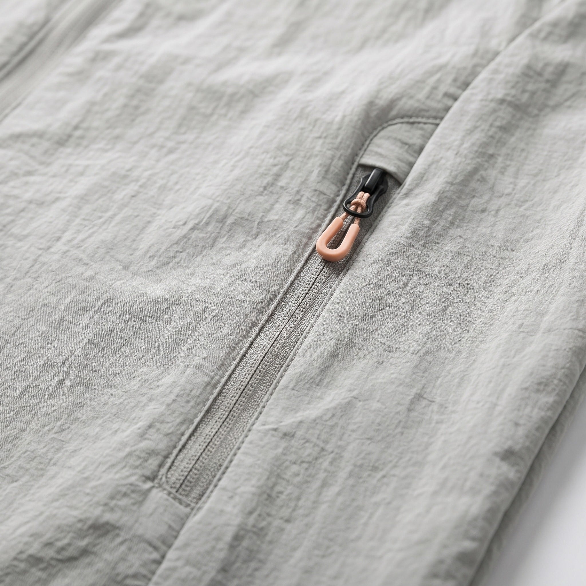 Close-up of gray jacket zip pocket with orange zipper pull | Chaps London