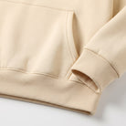 Beige fleece hoodie close-up showing kangaroo pocket and ribbed cuff detail | Chaps London