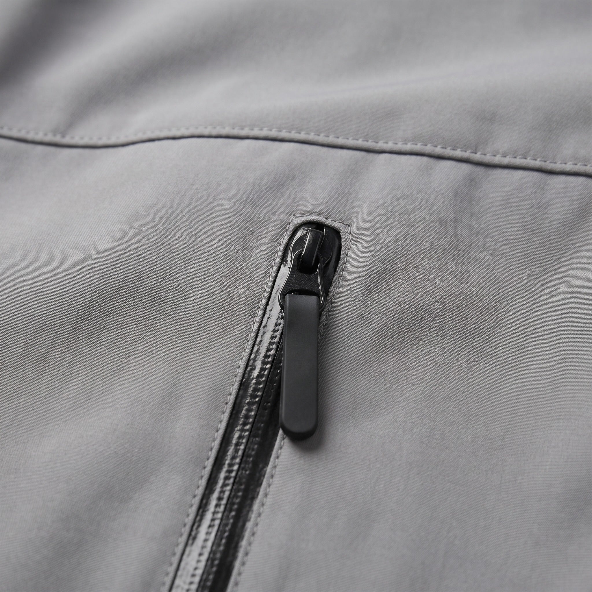 Close-up of gray jacket zip pocket with dark zipper pull | Chaps London