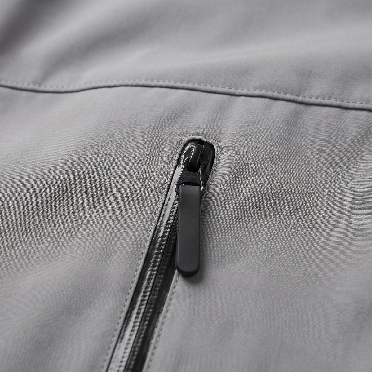 Close-up of gray jacket zip pocket with dark zipper pull | Chaps London