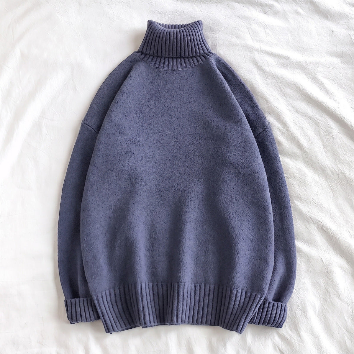 Slate blue oversized turtleneck sweater with ribbed cuffs, laid flat | Chaps London