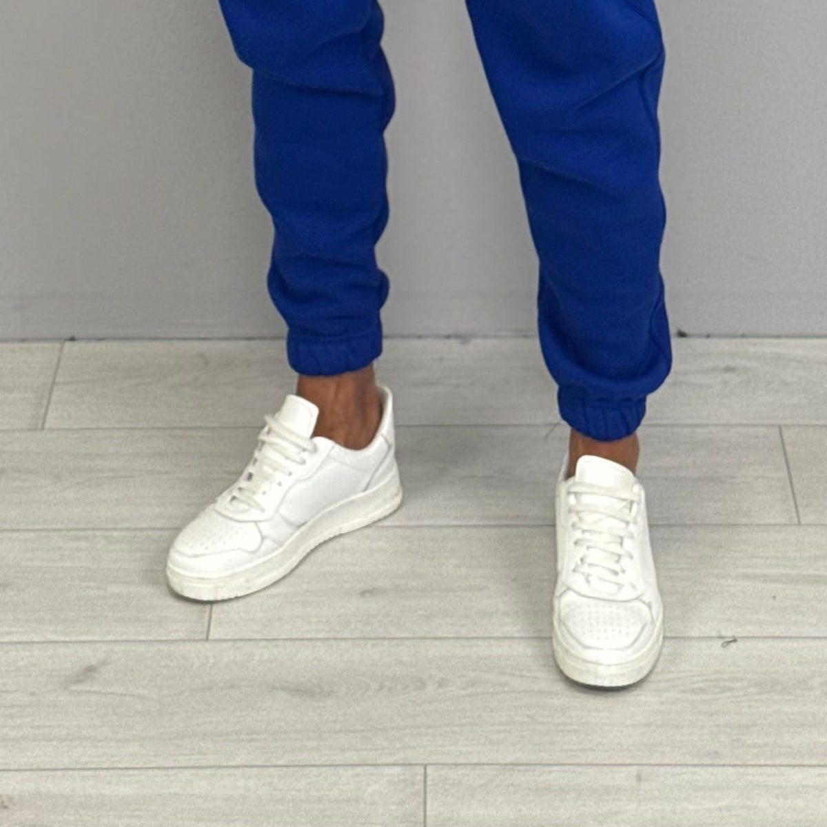 Blue cuffed jogger pants worn by person with white sneakers | Chaps London