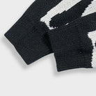 Black and white knit sweater cuffs with ribbed texture, close-up flat view | Chaps London