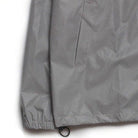 Gray waterproof jacket detail showing zippered pocket and elastic hem cord | Chaps London