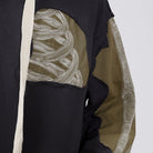 Close-up of black hoodie with olive panels and bone embroidery detail | Chaps London