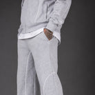Worn light grey tracksuit pants with white piping, side pocket detail, close-up view | Chaps London
