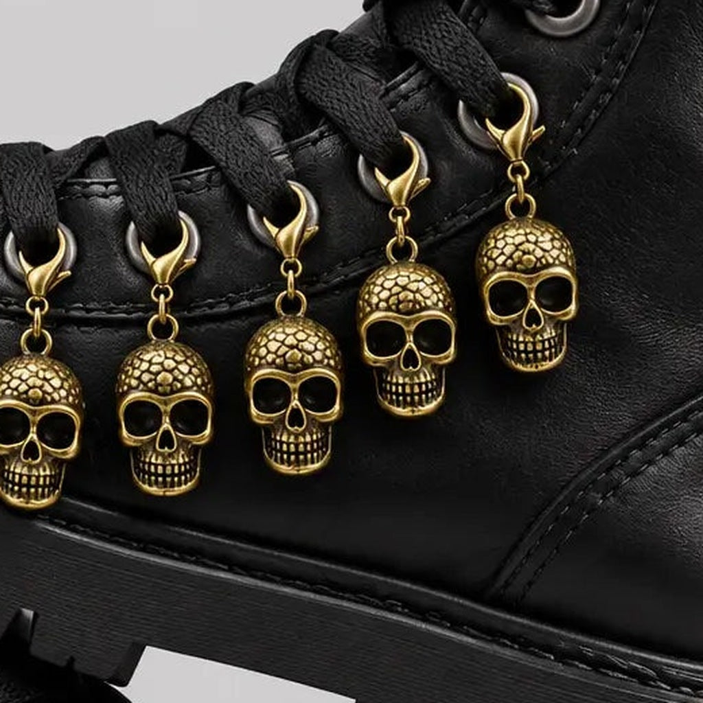 Gold skull charms with lobster clasps attached to black boot laces | Chaps London