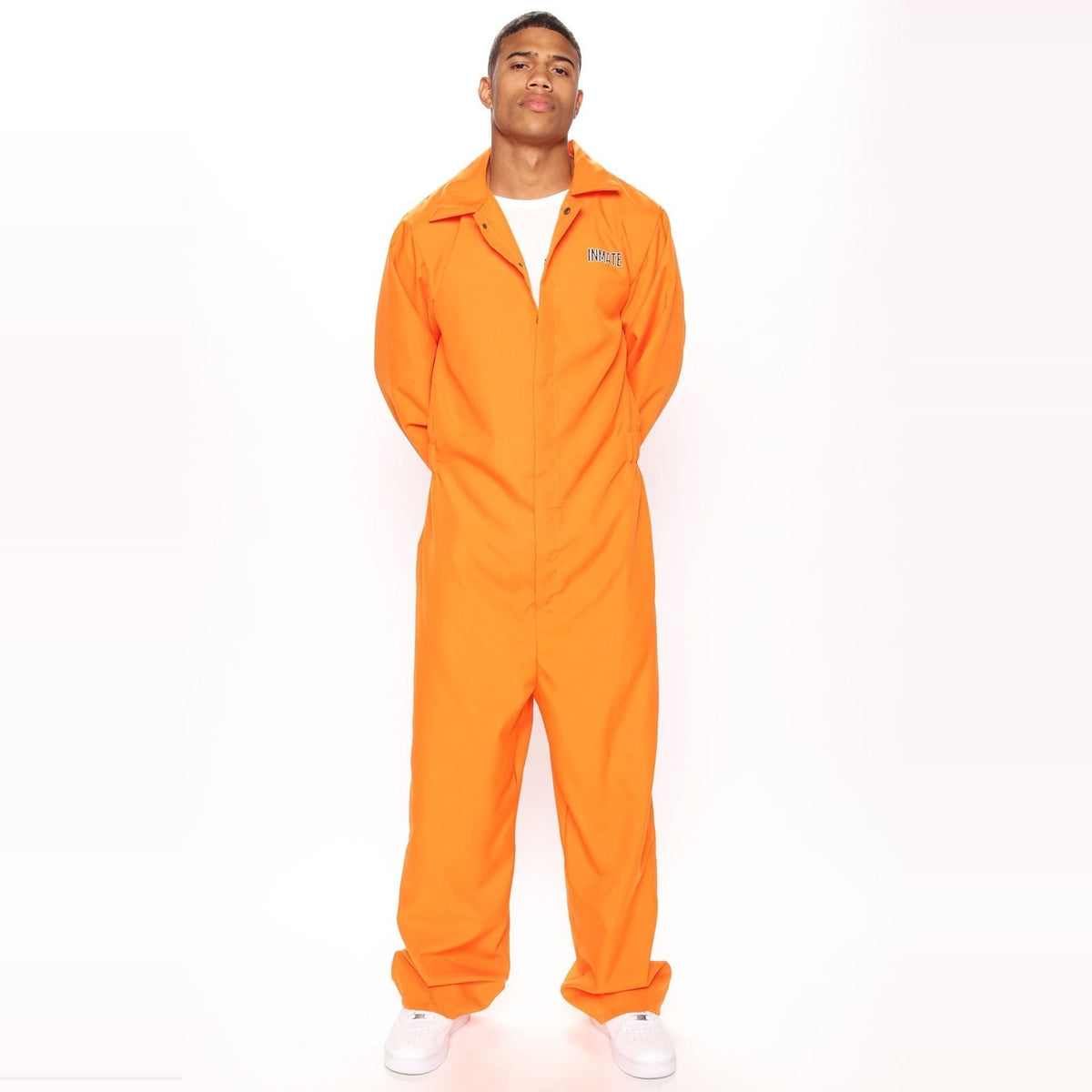 Man wearing orange jumpsuit costume with white sneakers, standing against plain background | Chaps London