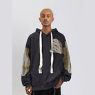 Worn by man, dark gray hoodie with olive patchwork, oversewn skeleton embroidery details | Chaps London