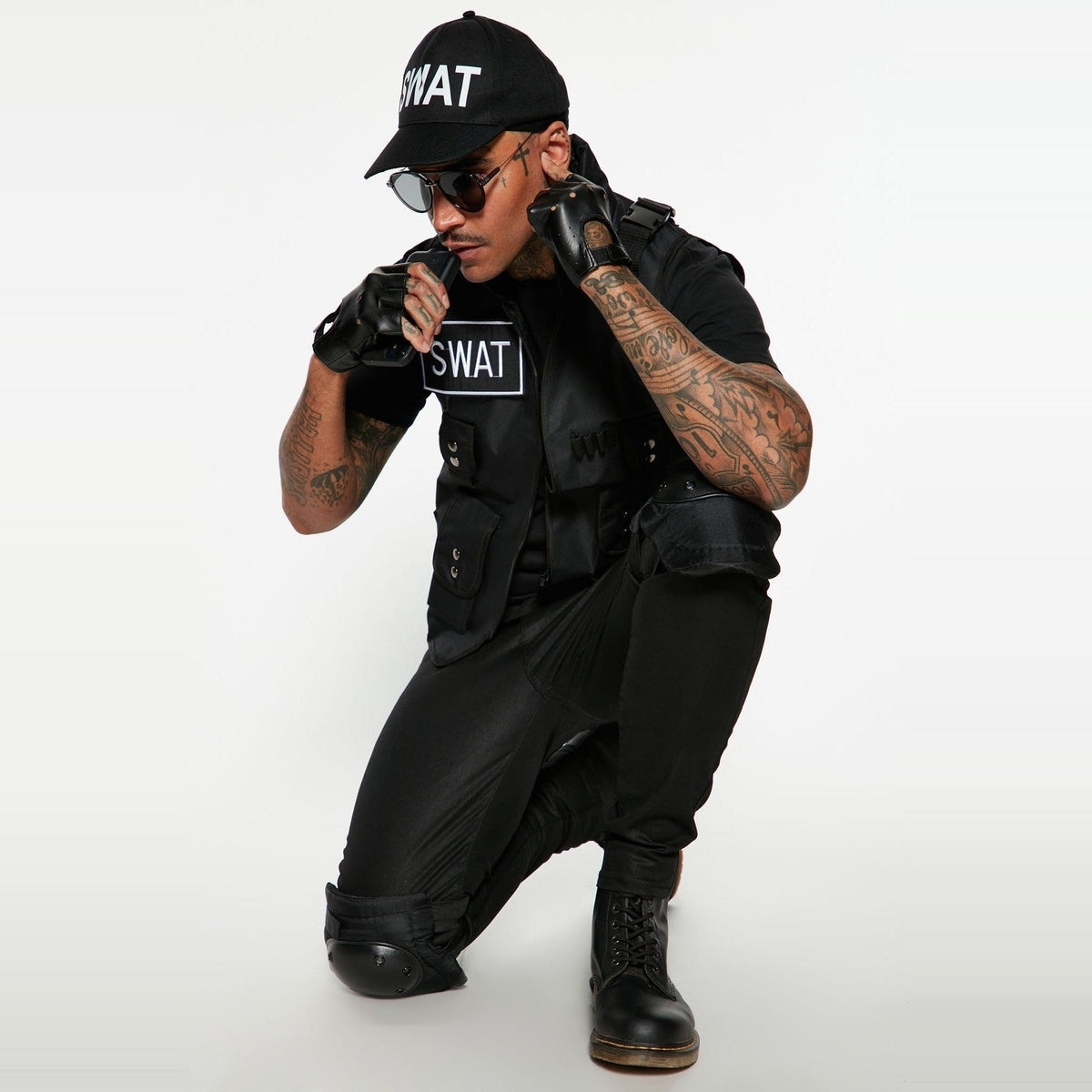 Man wearing black SWAT costume with vest, cap, gloves, kneeling pose | Chaps London