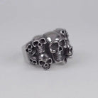 Silver-toned multiple skull cluster ring shown flat against plain background | Chaps London