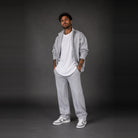 Man wearing light grey zip jacket, white t-shirt, and matching grey sweatpants | Chaps London