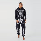 Man wearing black hooded skeleton onesie with white bone print, standing | Chaps London