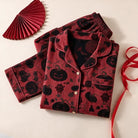 Red and black pumpkin print pyjama set folded flat with ribbon | Chaps London