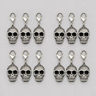 Twelve silver skull charms with lobster clasps, laid flat in rows | Chaps London