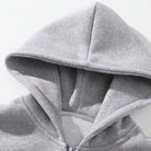 Close-up of gray hoodie zipper and hood detail, worn by person | Chaps London