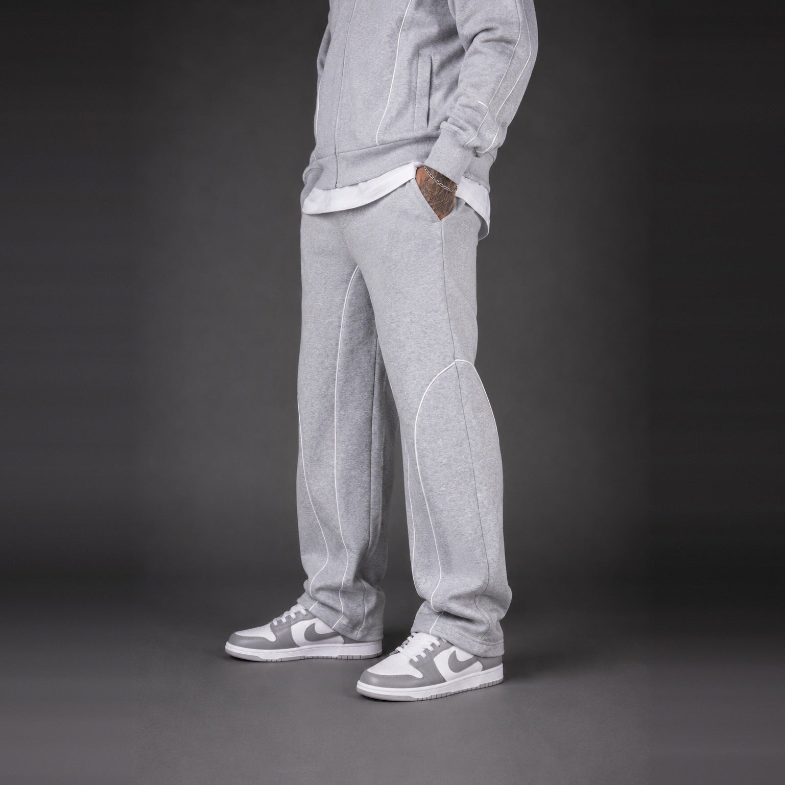 Light grey tracksuit pants worn by person, paired with grey sneakers | Chaps London