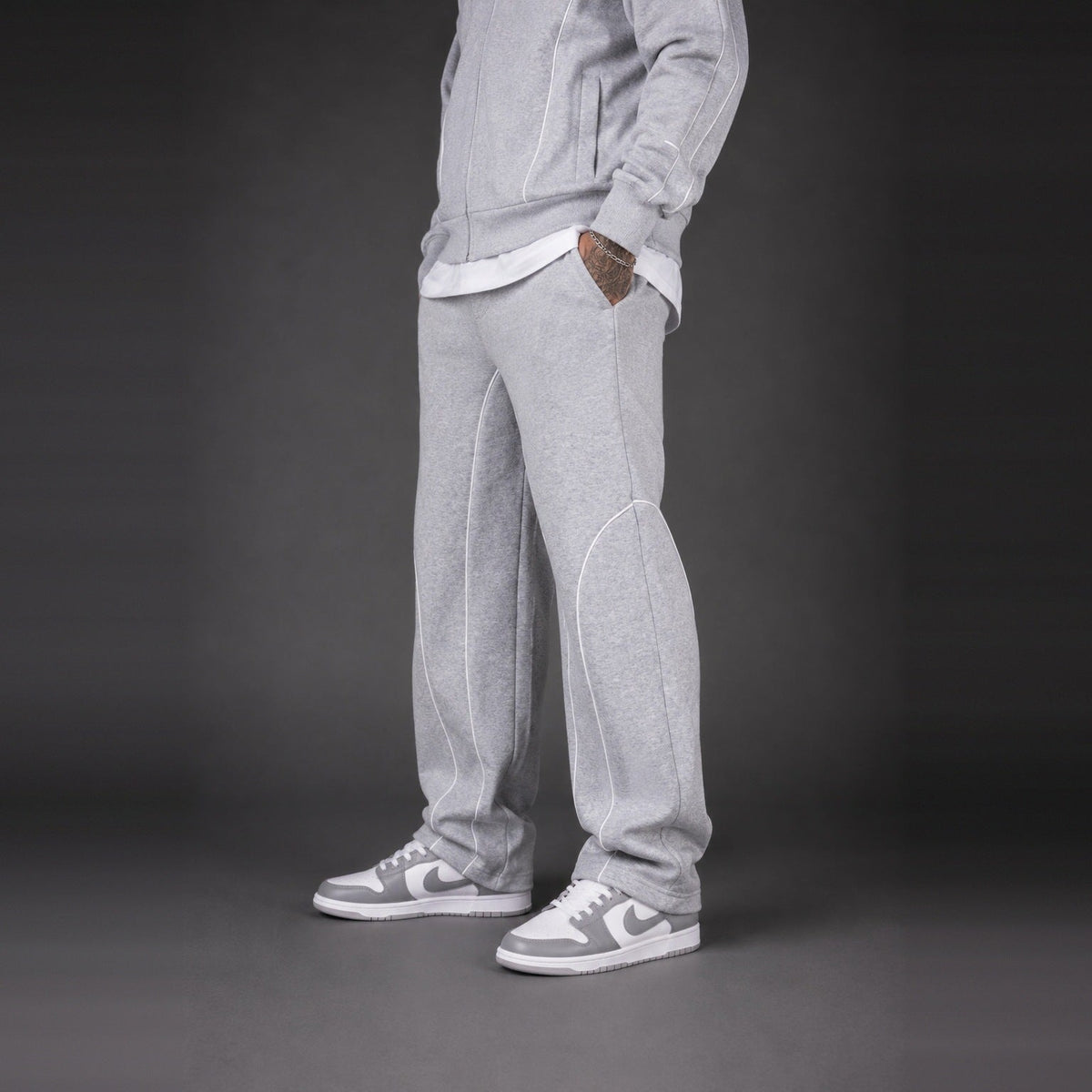 Light grey tracksuit pants worn by person, paired with grey sneakers | Chaps London