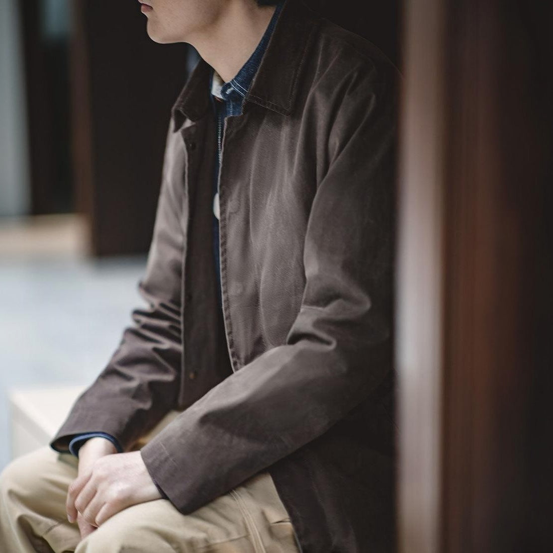 Man wearing brown jacket with denim shirt, seated indoors | Chaps London