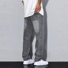 Man wearing gray washed denim wide-leg jeans with white shirt and sneakers | Chaps London