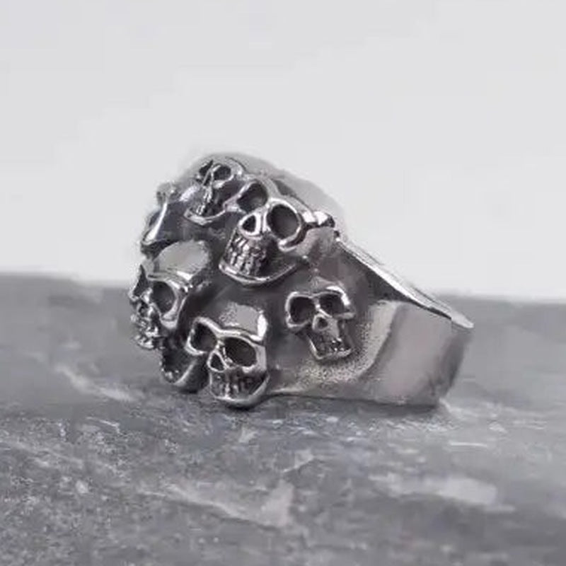 Silver skull-cluster ring on dark rock, flat product shot | Chaps London