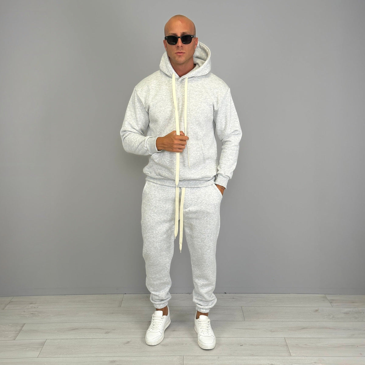Man wearing grey marl hoodie and matching cuffed jogger tracksuit outdoors | Chaps London