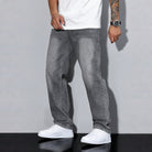 Man wearing gray washed denim wide-leg jeans with white t-shirt and sneakers | Chaps London