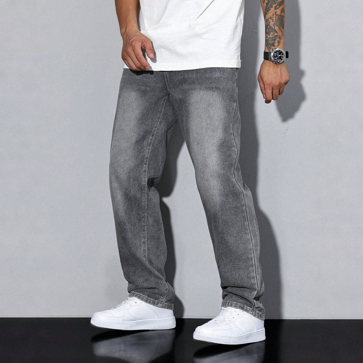 Man wearing gray washed denim wide-leg jeans with white t-shirt and sneakers | Chaps London