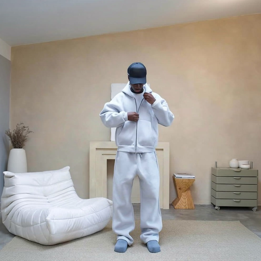 Man wearing white oversized zip hoodie and matching wide leg joggers indoors | Chaps London