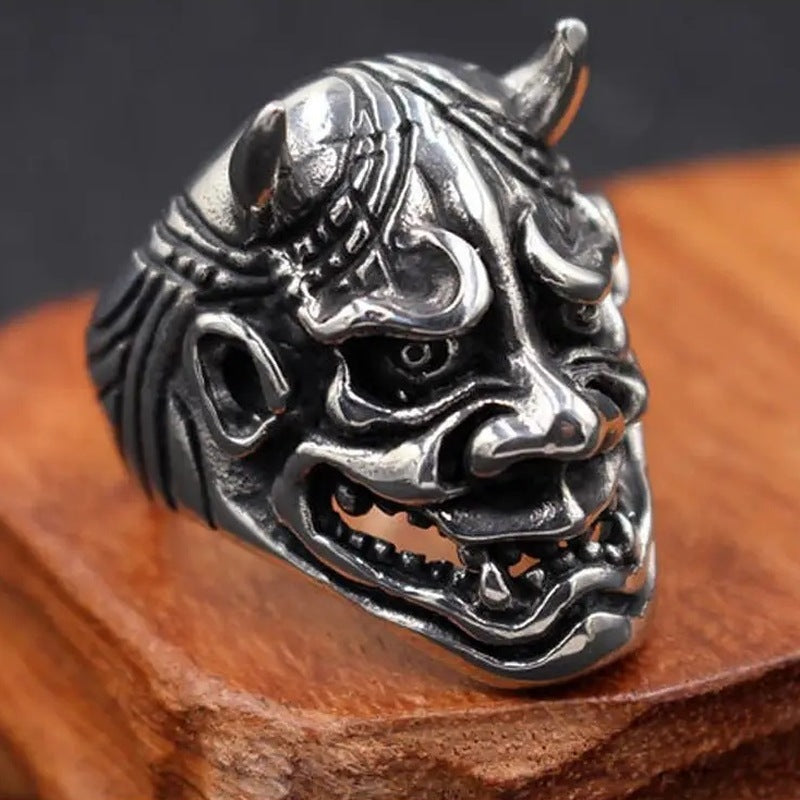 Silver Oni demon mask ring with horns, displayed on wood | Chaps London