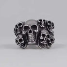 Silver skull ring with multiple faces, shown against plain gray background | Chaps London