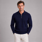 Man wearing navy quarter zip polo jumper with white trousers | Chaps London