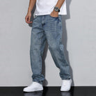Man wearing washed blue baggy denim jeans with white sneakers, worn look | Chaps London