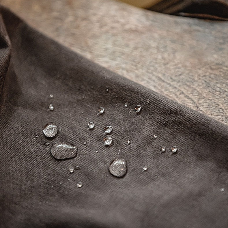 Water droplets beading on dark brown waxed fabric close-up detail | Chaps London