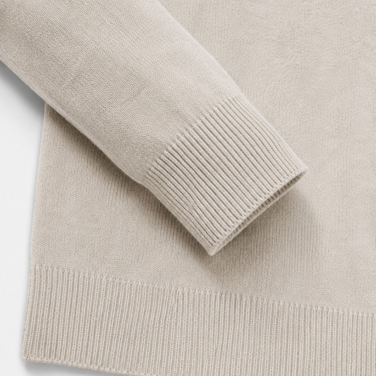 Close-up of beige knit sweater cuff and hem detail, flat lay | Chaps London