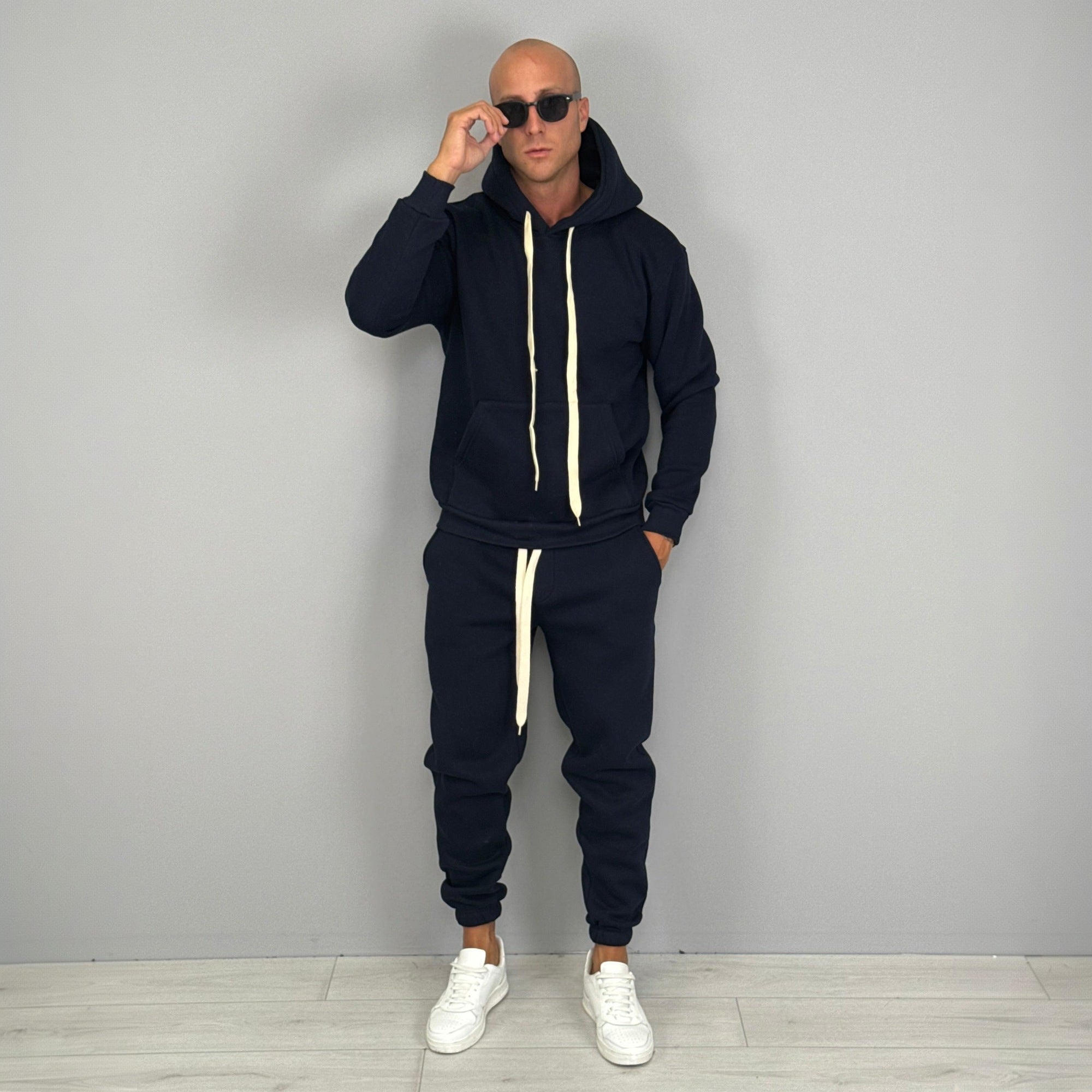 Man wearing navy hoodie tracksuit with matching cuffed joggers and sunglasses | Chaps London