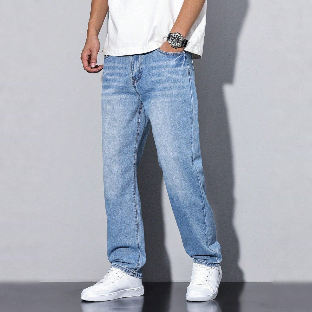 Man wearing light blue wide-leg washed denim jeans with white sneakers | Chaps London