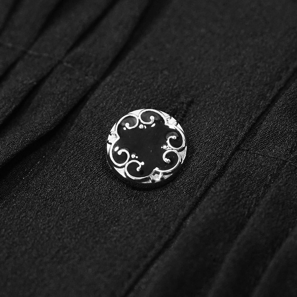 Black round button with ornate silver scrollwork design on pleated fabric | Chaps London