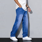 Man wearing light blue washed wide leg denim jeans with white shoes | Chaps London