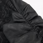 Close-up of black gathered elasticized cuff with subtle circuit pattern fabric | Chaps London