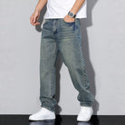 Man wearing washed blue wide-leg denim jeans with white sneakers, worn look | Chaps London
