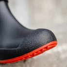 Black ankle welly close-up with textured toe and red ridged sole, worn | Chaps London