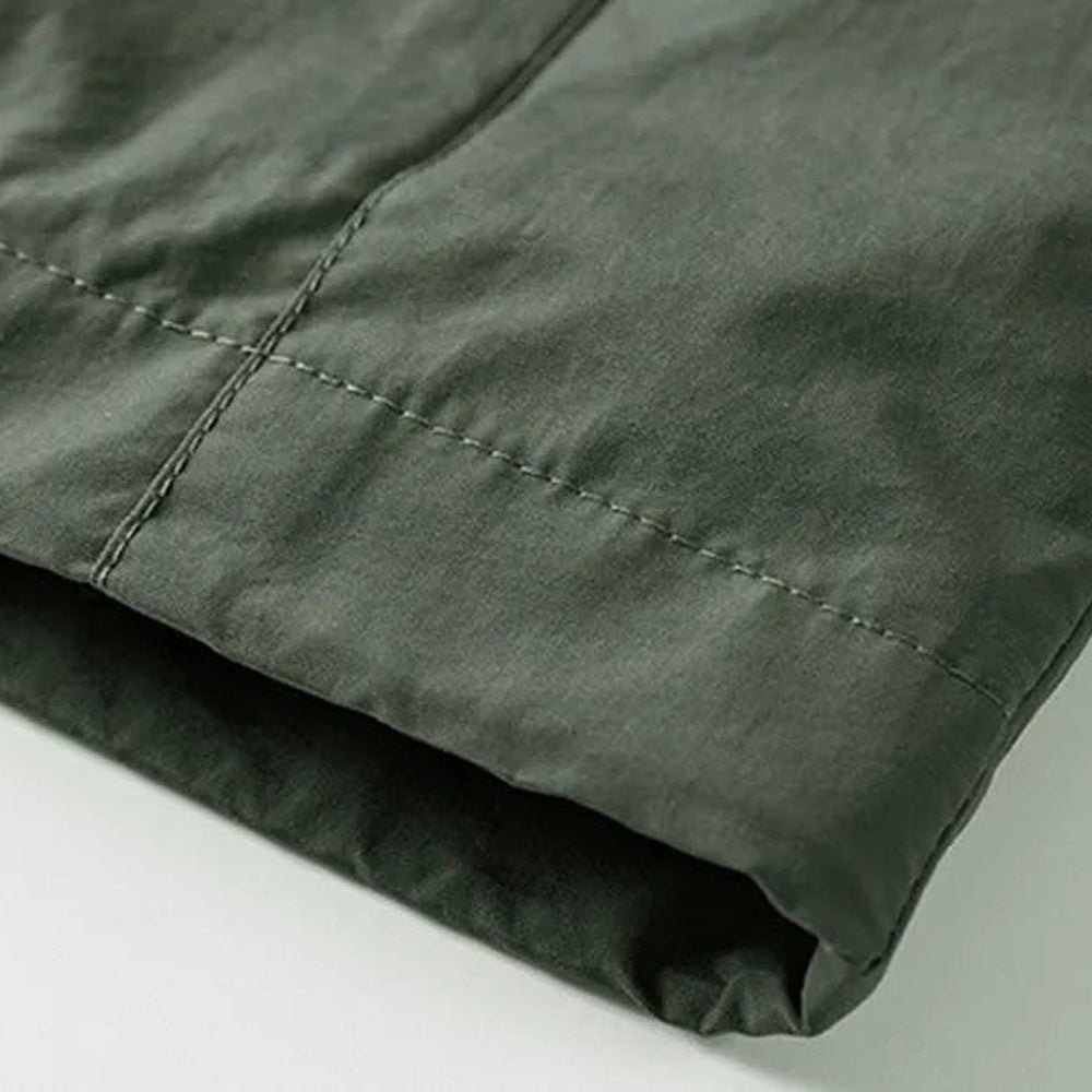 Close-up of dark green jacket fabric showing stitched seam detail flat | Chaps London