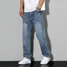 Man wearing light blue washed denim wide leg jeans with white sneakers | Chaps London
