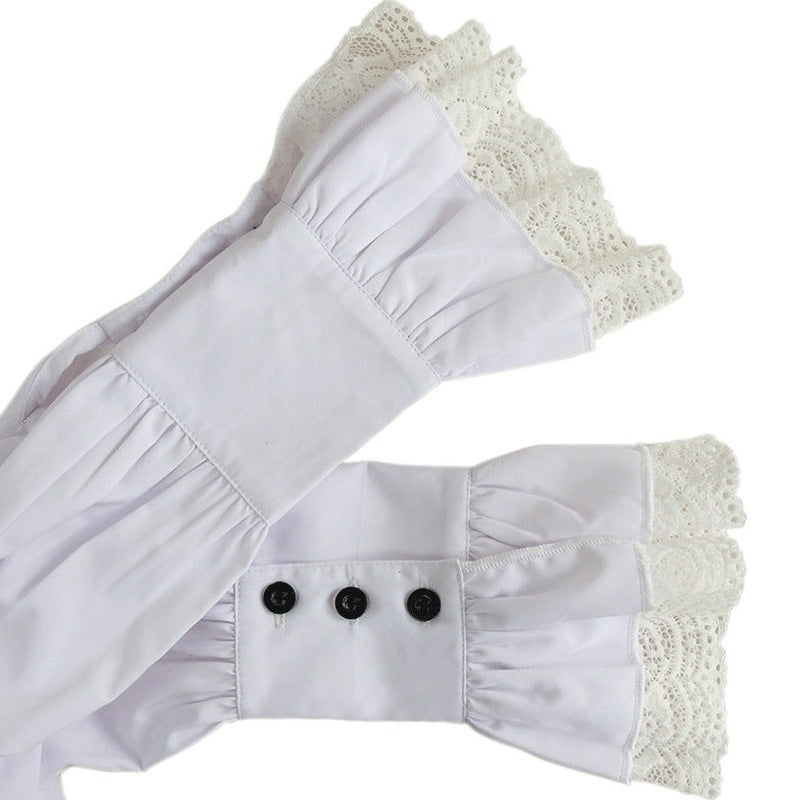 White lace-trimmed ruffle cuffs with black button detail, flat lay | Chaps London