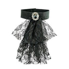 Black satin choker with layered lace ruffle and oval gemstone brooch, flat lay | Chaps London