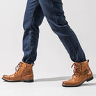 Man wearing brown leather lace-up boots with buckle strap and dark jeans | Chaps London
