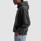 Man wearing oversized washed black hoodie with kangaroo pocket, side view | Chaps London